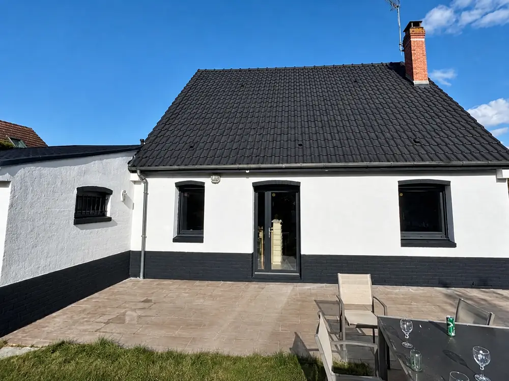 Maison après rénovation complète - peinture de toiture noire et ravalement de façade blanc